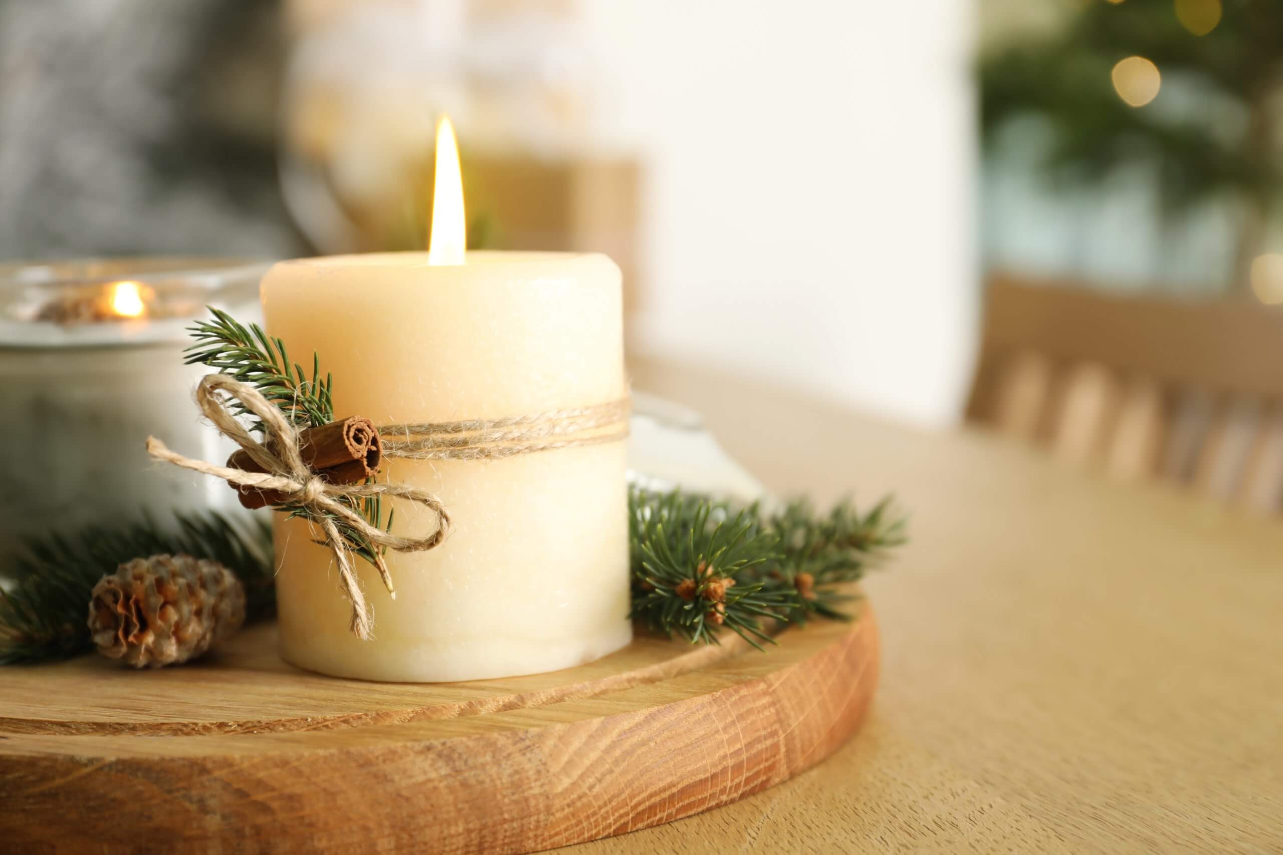 Brennende duftende Nadelkerzen und Weihnachtsdekor auf Holztisch